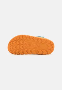 Oransje gummiyttersåle med et sikksakk mønster, med "PRIMIGI"-logoen preget. Egnet for utendørsaktiviteter.