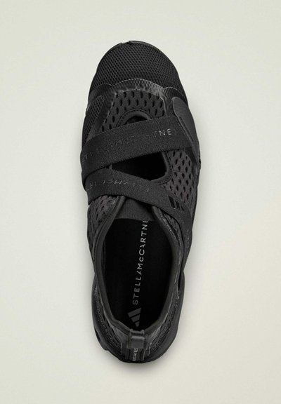 Black athletic shoe with a mesh upper. Features crisscross straps and a rounded toe. Interior shows branding in contrasting colors.