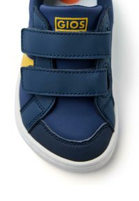 Baskets bleues avec des accents jaunes, comportant deux bandes Velcro, en matière synthétique lisse et avec une semelle en caoutchouc texturé.