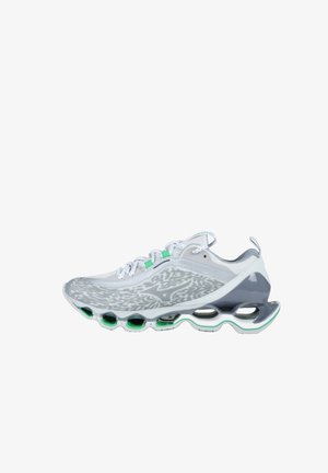 Scarpa da ginnastica bianca e grigia con dettagli verdi, chiusura frontale con lacci e suola segmentata unica progettata per ammortizzazione e supporto.