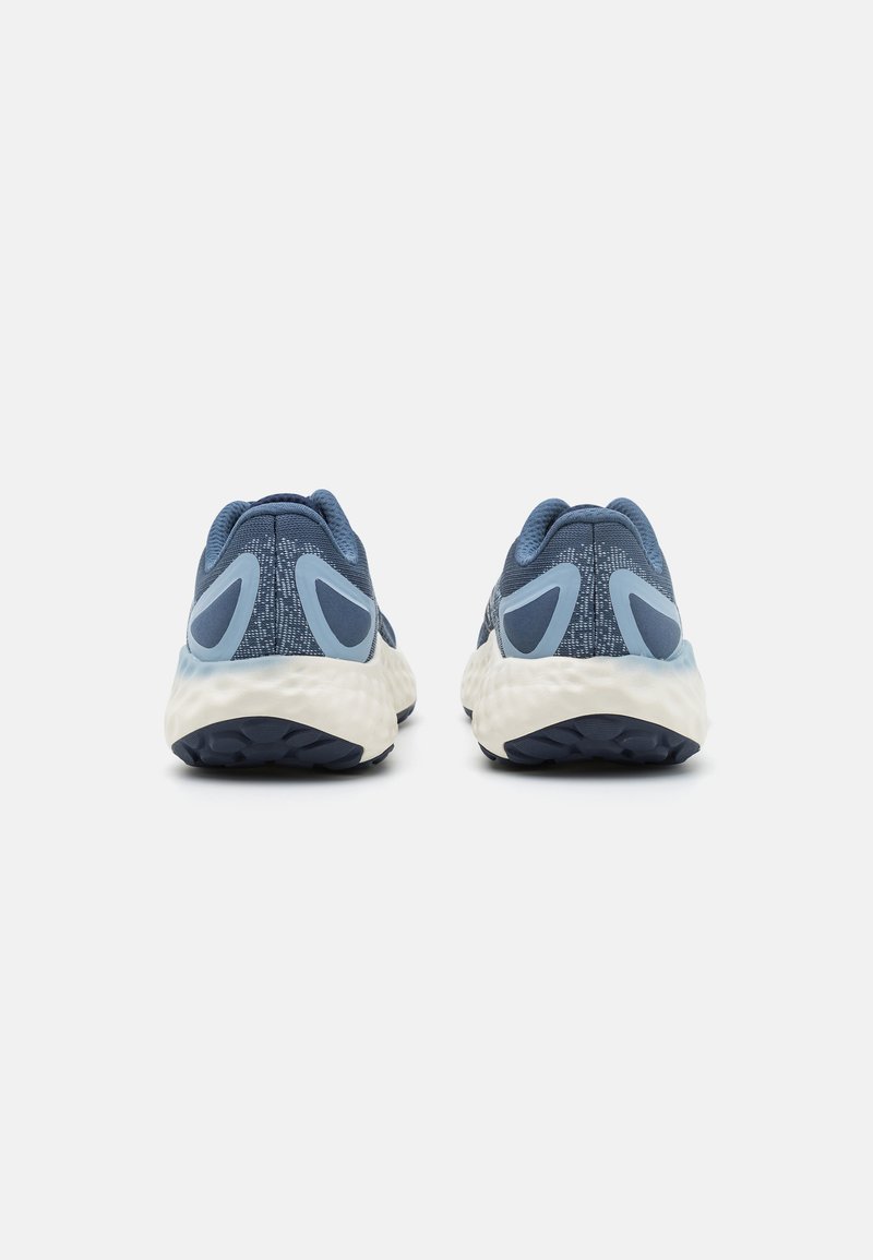 Zapatillas deportivas de color azul claro con una parte superior de malla texturizada, acentos en azul oscuro y una suela blanca acolchada con un patrón de tracción en negro.