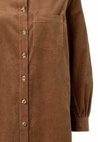 Rochie cămașă maro din catifea cu dungi verticale, închidere cu nasturi și buzunar la piept. Mâneci lungi cu mansete strânse.