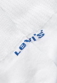 Fehér, puha pamut keverékből készült zoknik, a szárán kék "Levi's" logóval hímezve a márkázás érdekében. Egyszerű és sima textúra.