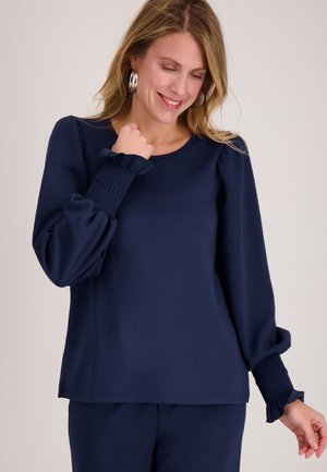 Donkerblauw long-sleeve top met een ronde halslijn en geplooide manchetten. Voorzien van geplooide accenten op de mouwen; zachte, gestructureerde stof.