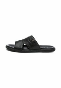 Sandalia de slide de cuero negro con un diseño de tiras cruzadas, detalles texturizados y una suela de goma. Presenta un pequeño logotipo en la tira.