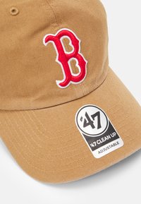 Braune Baumwoll-Baseballmütze mit rotem gesticktem "B"-Logo und verstellbarem Riemen, mit einem Etikett, das "47 CLEAN UP" liest.