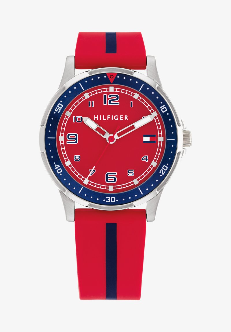 Rote Analog-Uhr mit Edelstahlgehäuse, blauer Lünette und passendem Silikonarmband. Mit weißen Stundenmarkierungen und Markenlogo auf 12 Uhr.