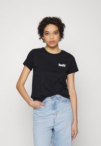 Camiseta negra de manga corta con el logo blanco de "Levi's" en el lado izquierdo del pecho. Fabricada en suave algodón, con cuello redondo clásico y corte relajado.