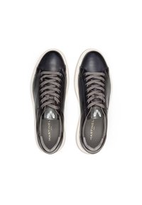 Zapatillas de cuero negro con cordones grises, suela de goma blanca, punta redondeada y logo en la plantilla. Textura suave con un diseño minimalista.