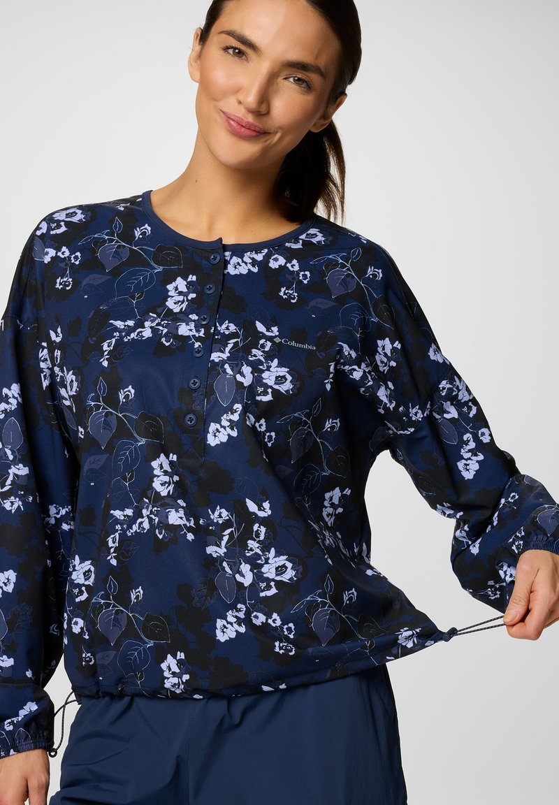 Langärmliges, marineblaues Oberteil mit floralem Muster in Blau und Weiß. Mit Knopfverschluss und verstellbarem Kordelzug am Saum für eine anpassbare Passform. Weicher Stoff.