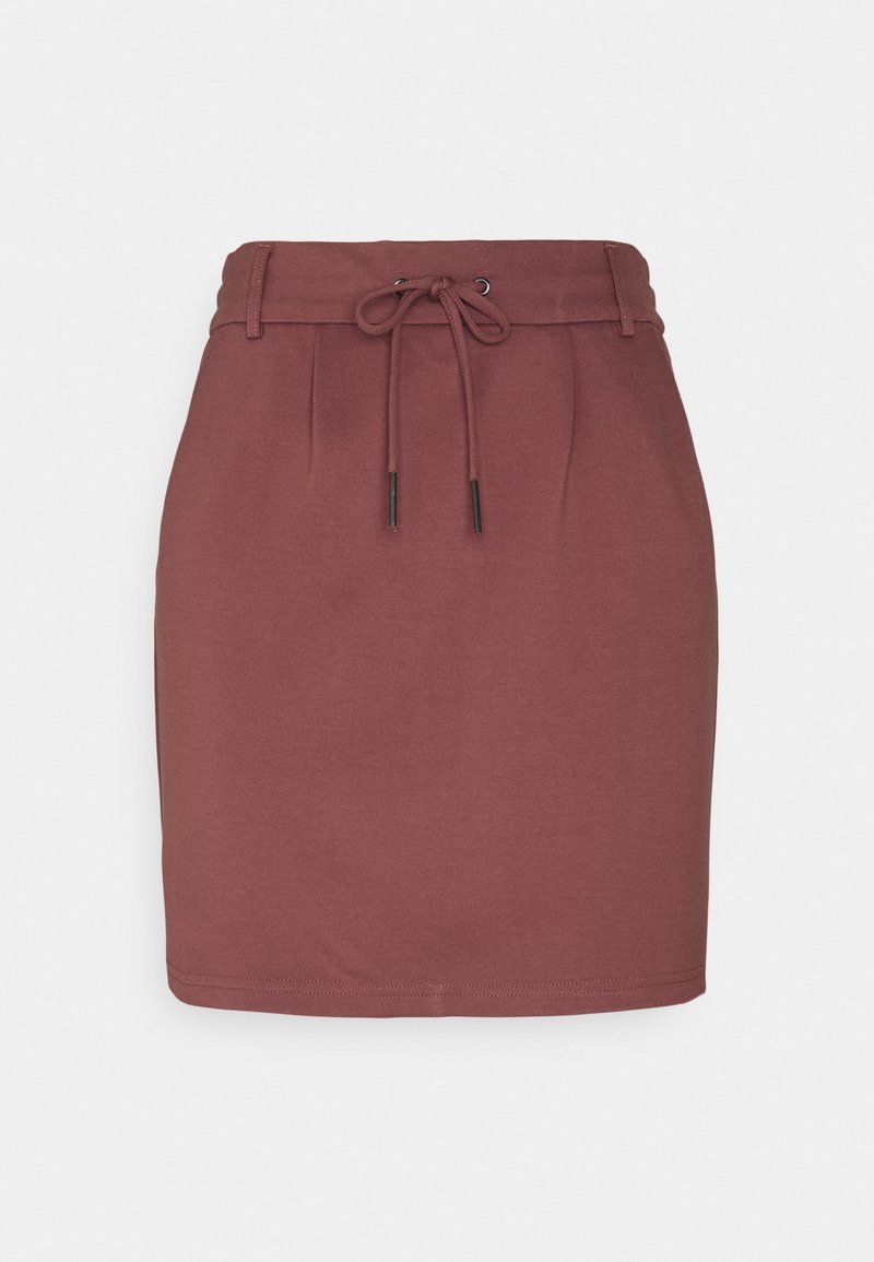Jupe mauve taille haute, longueur genou, avec passants pour ceinture et cordon à nouer devant sur fond blanc uni.