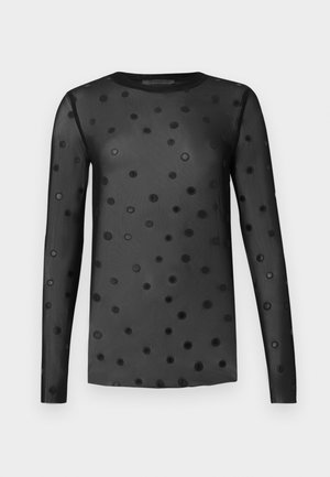 Melnas, caurspīdīgas auduma garroku tops ar dažāda izmēra melnu punktu rakstu visā virsmā. Apaļa kakla izgriezuma un pieguļošas piedurknes.