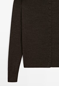 Cardigan buttonato marrone scuro con maniche e parte inferiore in tessuto lavorato a maglia, con polsini e orlo a coste su sfondo bianco.