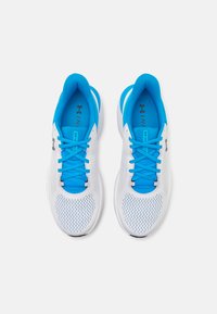 Scarpe da ginnastica bianche con accenti blu, dotate di una tomaia in rete, linguetta imbottita e lacci piatti. La suola presenta un motivo di presa testurizzato.