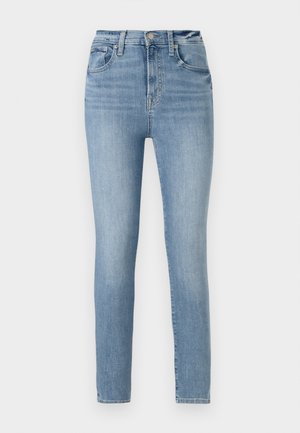 Light blue high-waisted jeans with a slim fit, featuring five pockets and a zipper fly, made of denim with a smooth texture.