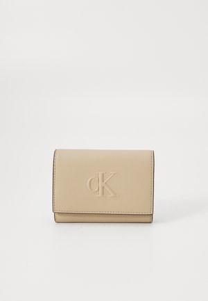 Beige leather wallet with embossed "cK" logo, rectangular shape, soft texture, and visible stitching along the edges.