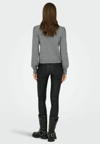 Grauer Strickpullover mit puffärmel, taillierter Silhouette, getragen mit schwarzen Slim Pants und schwarzen Ankle Boots mit Schnallenakzenten.