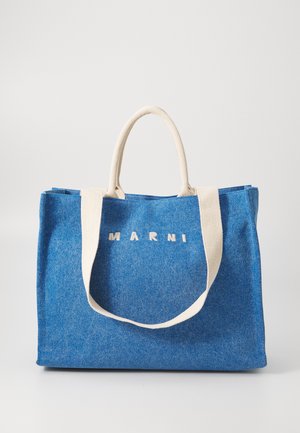 Borsa tote in denim blu con manici crema e la scritta "MARNI" stampata in lettere crema sul davanti, su uno sfondo bianco semplice.