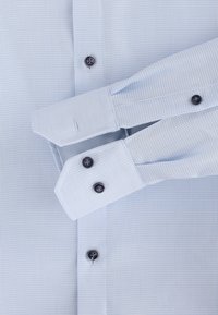 Lichtblauw geruit overhemd met lange mouwen, button-down kraag, donkere knopen en contrasterende manchetafwerking. Textuurstof.
