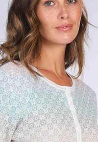 Leichter, gestrickter Cardigan in Weiß mit einem Farbverlauf, der sanfte Aqua- und Grautöne zeigt. Knöpfe vorne und ein runder Ausschnitt.