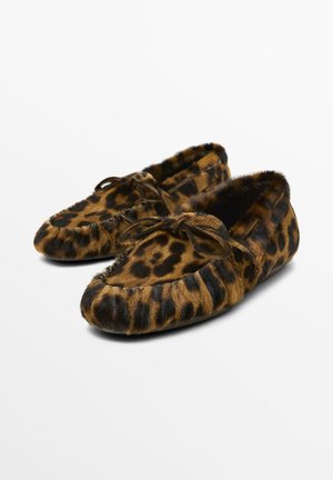 Pantofole con stampa leopardata realizzate in morbido materiale di pelliccia, con punta rotonda, dettaglio a fiocco nella parte anteriore e finitura in tessuto morbido.