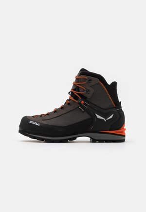 Black and gray hiking boot with orange laces, mesh paneling, rubber toes, and textured soles. Features a raised orange heel.