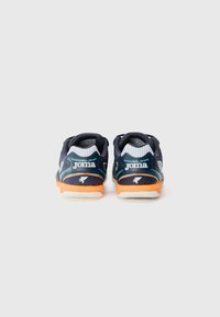 Chaussures de sport de marine avec dessus en mesh, accents blancs et semelle orange. Présente un logo et un motif texturé. La vue arrière montre un design bicolore.