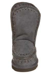 Bota de ante gris con una forma alta y redondeada, que presenta costuras visibles y una superficie suave y texturizada. La suela es plana y resistente.