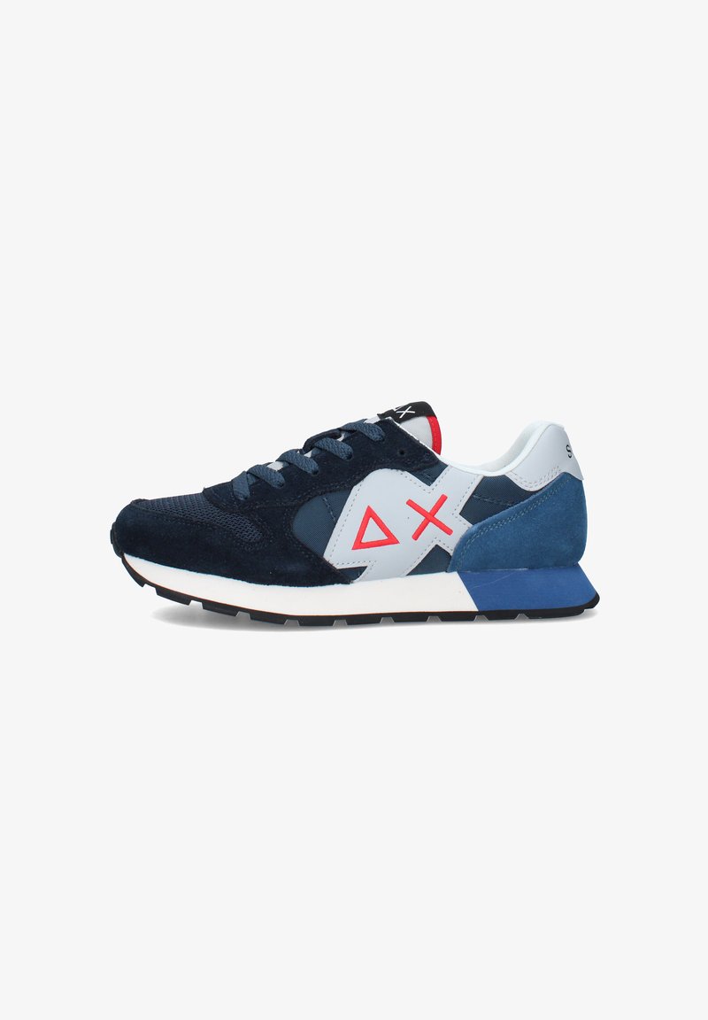 Scarpa da ginnastica blu navy e bianca con logo geometrico rosso, tessuti in mesh e scamosciato, e suola nera zigrinata, mostrata di profilo.