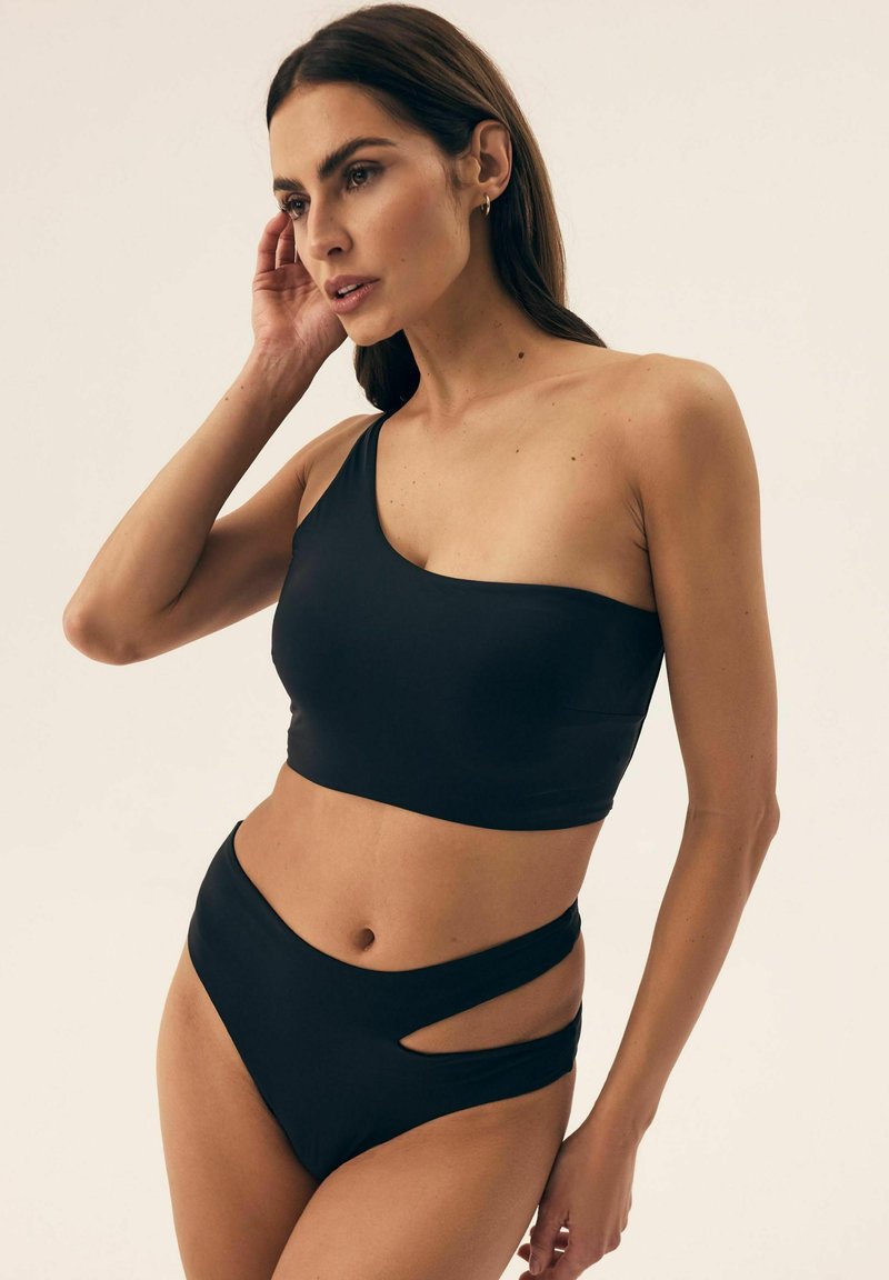 Czarny bikini na jedno ramię o gładkiej fakturze; kostium kąpielowy z wysokim stanem z bocznymi wycięciami dla dodatkowego efektu.