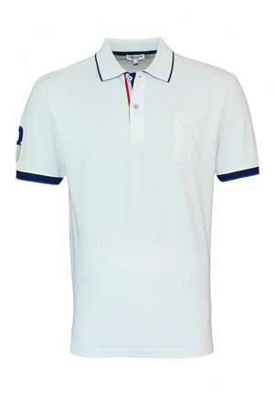 Weißes Poloshirt mit marineblauer Umrandung am Kragen und an den Ärmeln. Mit einem roten Akzent auf der Knopfleiste und einem bestickten Logo auf der Brust.