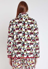 Set di pigiama in pile con sfondo bianco e grafica ripetuta di Topolino in nero, rosso e giallo. Decorato con colletto e polsini.