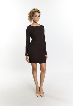 Rochie maro cu maneci lungi, cu textură ridată, talie bine definită și lungime scurtă. Modelul poartă pantofi cu toc nude. Material neted cu o textură subtilă.