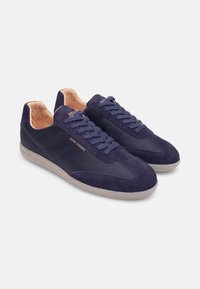 Navy-Suede-Sneaker mit einem eleganten Design, das ein glattes Textil-Obermaterial, eine runde Zehenpartie und eine Gummisohle aufweist. Das Innere hat ein beigefarbenes Lederfutter.