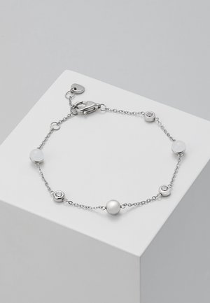 Bracelet chaîne argentée avec des petites perles blanches alternant avec des pierres transparentes, doté d'un fermoir mousqueton et d'un petit pendentif en forme de cœur.