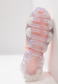 Suela de zapato con un diseño translúcido en rosa y blanco, que presenta un acolchado redondeado y elevado, así como un patrón texturizado para mejorar el agarre.