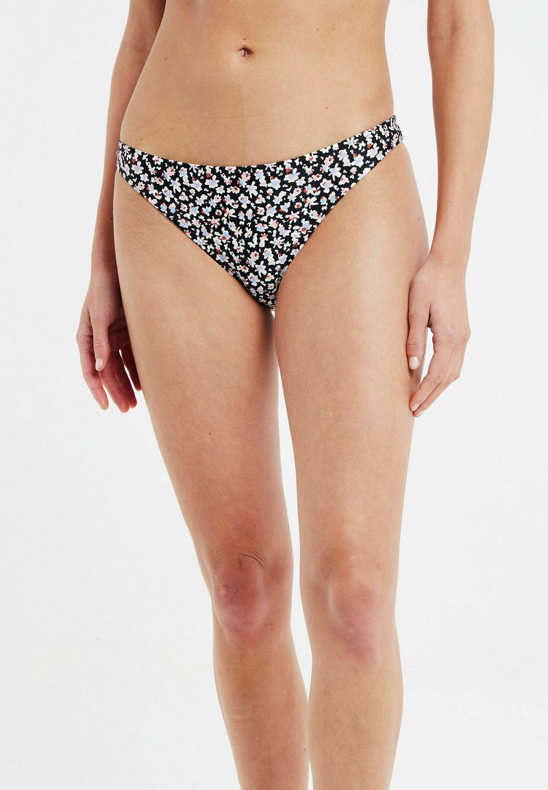 Parte inferior de bikini negra con un estampado floral en blanco, rosa y azul. Diseño de tiro bajo con bordes suaves y cobertura moderada.