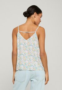 Bloemige tanktop in pastelblauw met roze en gele accenten, voorzien van dunne spaghettibandjes en een V-vormig rugontwerp, gemaakt van lichtgewicht stof.