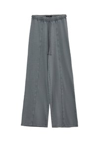 Pantalons larges gris en tissu doux avec une taille élastique et un cordon de serrage, présentant des détails de couture sur le devant.