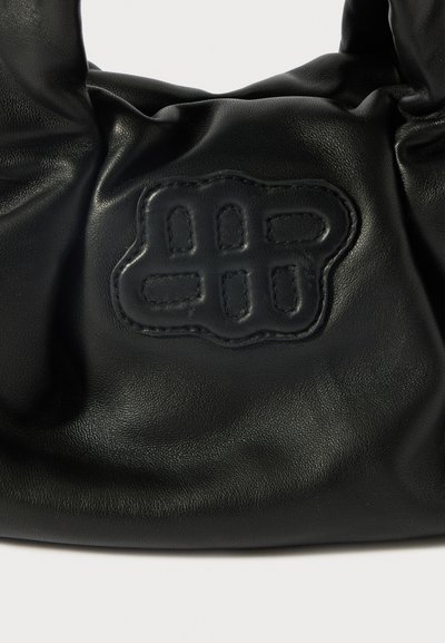 Μαύρη δερμάτινη τσάντα με μαλακή, ζαρωμένη υφή. Περιλαμβάνει ένα εξέχον ανάγλυφο λογότυπο σε στρογγυλό σχήμα στο μπροστινό μέρος.