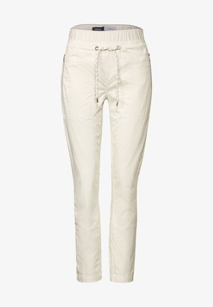 Pantalones crema claros hechos de una tela suave, con una cintura elástica, cordón y dos bolsillos laterales con cierres de cremallera.