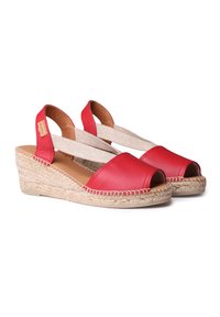Sandali con zeppa in pelle rossa, con punte scoperte, cinghie incrociate elastiche e tacchi avvolti in iuta. Texture liscia, design casual, costruzione leggera.
