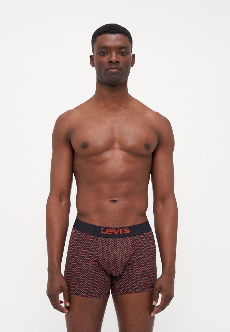Boxershorts i röd och marinblå med ett geometriskt mönster. Elastisk midja med logotyp. Materialet verkar mjukt och sitter nära kroppen.