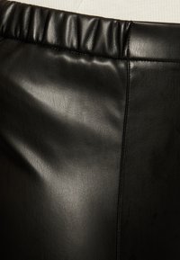 Black leather skirt featuring a gathered elastic waistband, smooth texture, and side seam detailing.