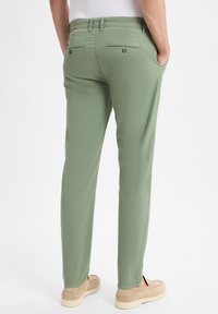 Hellgrüne Hose im Slim-Fit-Stil, mit Gesäßtaschen und Knopfverschluss, glatter Stofftextur und geradem Bein.