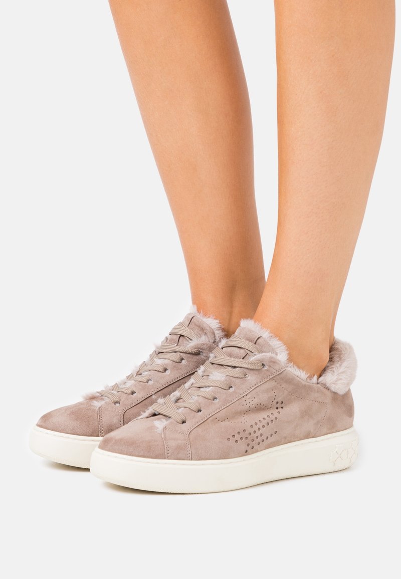 Zapatillas de ante beige con un suave cuello de un beis claro, cierre de cordones y detalles perforados en los laterales. Suela de goma blanca.