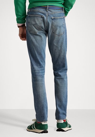 Jeans in denim azzurro chiaro con una forma aderente, cinque tasche, lievi sfumature e cuciture a contrasto in vita.