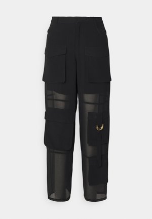 Pantaloni cargo neri con un mix di tessuto opaco e trasparente. Presentano diverse tasche, un accento di anello dorato e una vestibilità rilassata.