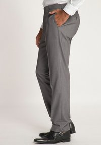 Pantaloni eleganti grigi realizzati in tessuto intrecciato, con un design a gamba dritta, tasche laterali e zip, abbinati a scarpe eleganti nere.