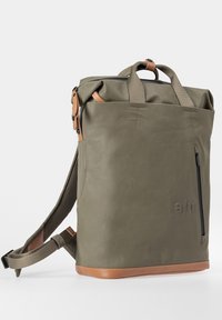 Olivgrüner Rolltop-Rucksack mit hellbraunen Lederakzenten, vorderer Reißverschlusstasche, zwei Griffen und verstellbaren, gepolsterten Schultergurten.